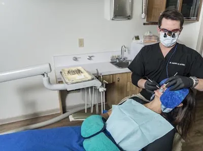 Dr. Oliveira checking up on a patient after she received dental implants