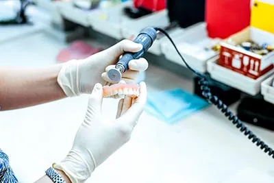 doctor putting the finishing touches on a set of dentures for a patient