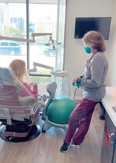 dental assistant speaking to general dentistry patient in chair